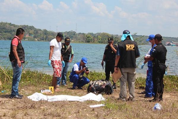 Autoridades examinan el maletín donde fueron localizado el cuerpo descuartizado de una persona junto al lago Petén Itzá. (Foto Prensa Libre: Rigoberto Escobar)<br _mce_bogus="1"/>