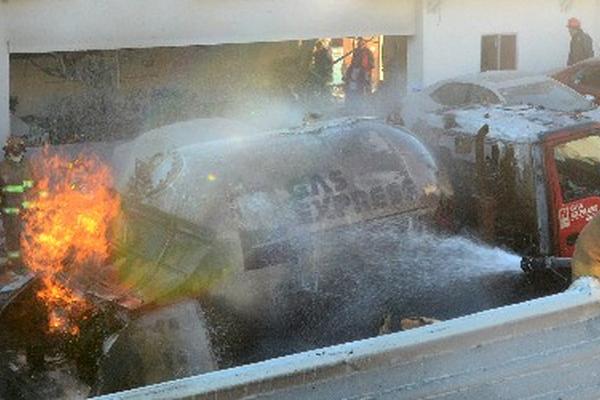 Bomberos mexicanos enfrían el contenedor del camión cisterna de gas que  estalló en el hospital de Cuajimalpa.(Foto Prensa Libre: EFE)