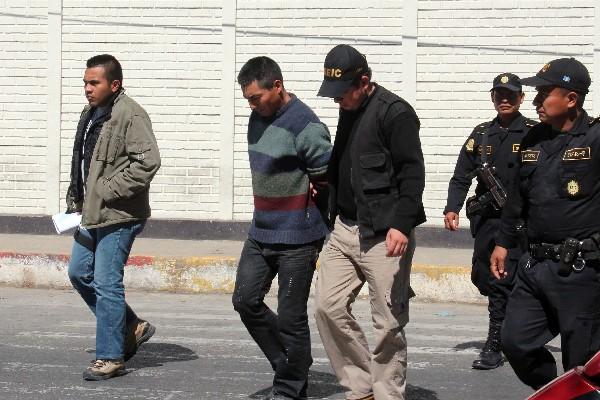 Pedro López  es conducido  por agentes policiales.