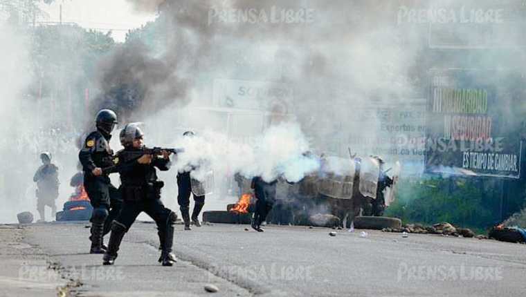 Agentes de  la PNC utilizaron gases lacrimógenos para retirar un bloqueo en el kilómetro 163 de la ruta al suroccidente. (Foto Prensa Libre: Hemeroteca PL).