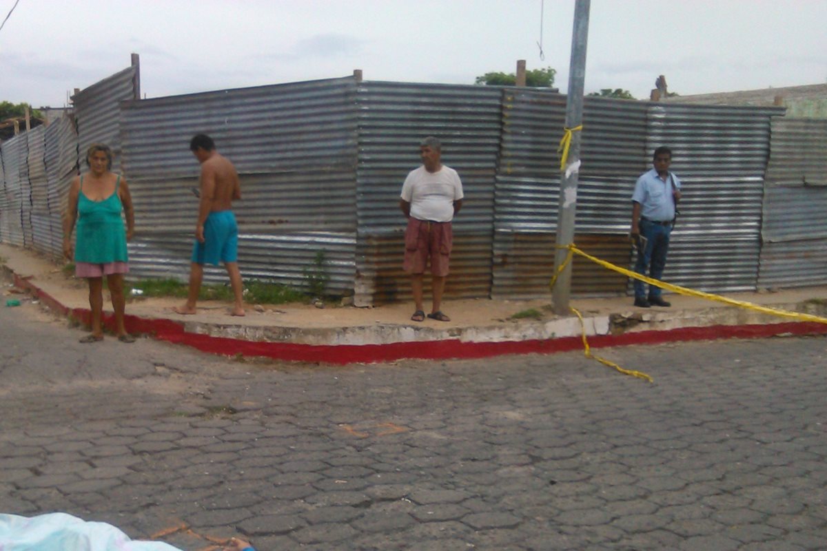 Vecinos de la cabecera de Chiquimula observan escena del crimen donde fue ultimado Víctor Hugo Valdez. (Foto Prensa Libre: Edwin Paxtor)