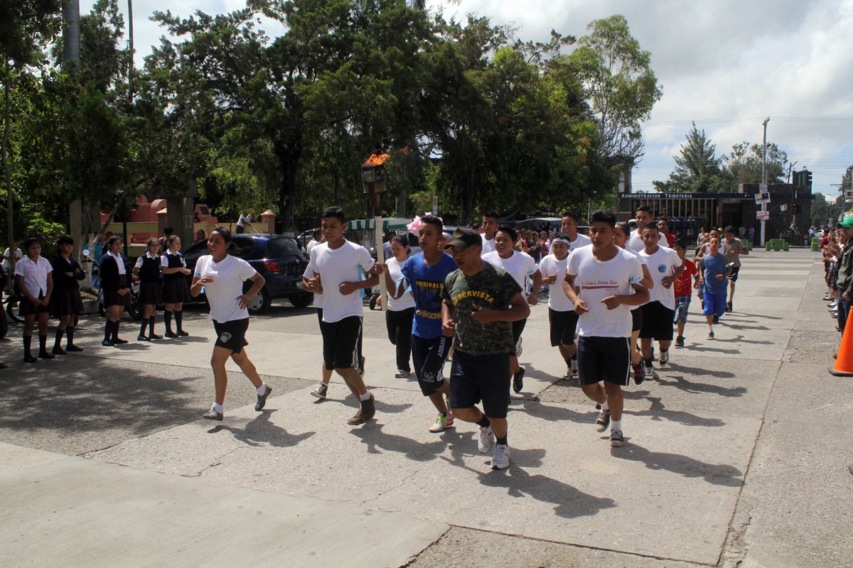 Jóvenes de Jalapa trotan y llevan una antorcha en la actividad Re-Créate por la Paz. (Foto Prensa Libre: Hugo Oliva)