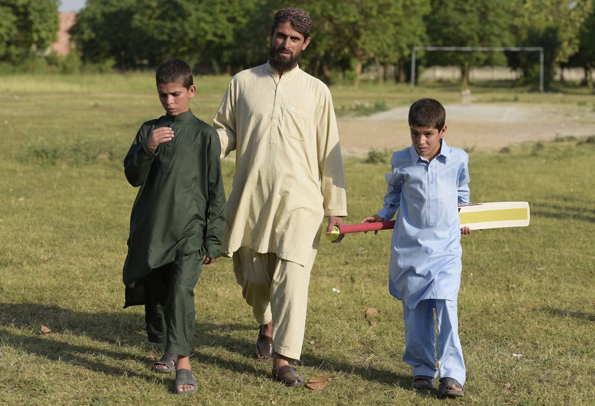 Shoaib Ahmed (derecha) y Abdul Rasheed (izquierda), los hermanos pakistaníes que sufren una extraña enfermedad, caminan junto a su padre (c), en los jardines del Instituto de Ciencias Médicas de Pakistán (PIMS) en Islamabad. (Foto Prensa Libre: EFE).
