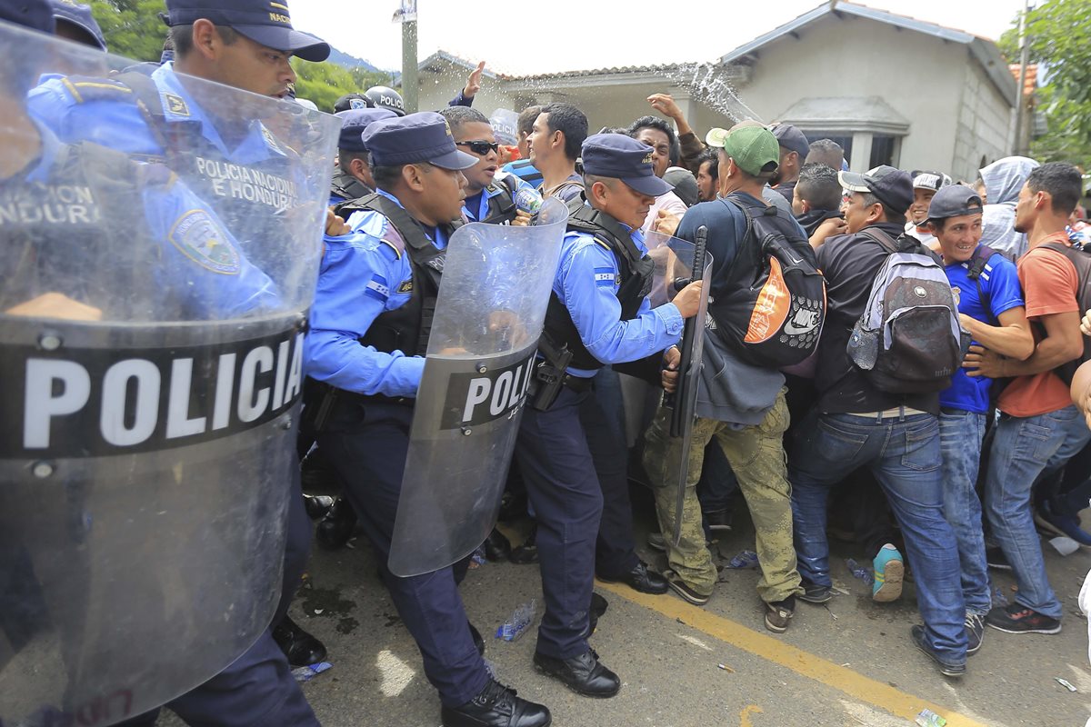 Centenares de migrantes hondureños intentan cruzar un retén policial para continuar su paso a Guatemala. (Foto Prensa Libre: EFE)