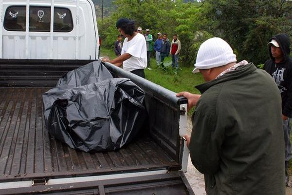 Dos hombres cargan los restos carbonizados del hombre localizado en Jalapa. (Foto Prensa Libre: Hugo Oliva)<br _mce_bogus="1"/>