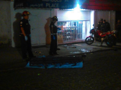 El cuerpo  de Aldo López quedó tendido frente al negocio. (Foto Prensa Libre: Bomberos Municipales)