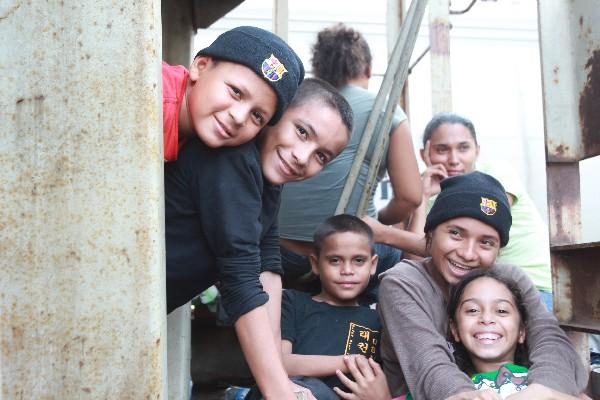 niños de   la familia Matamoros Zelaya, de Honduras, sonríen, su mamá observa pensativa.