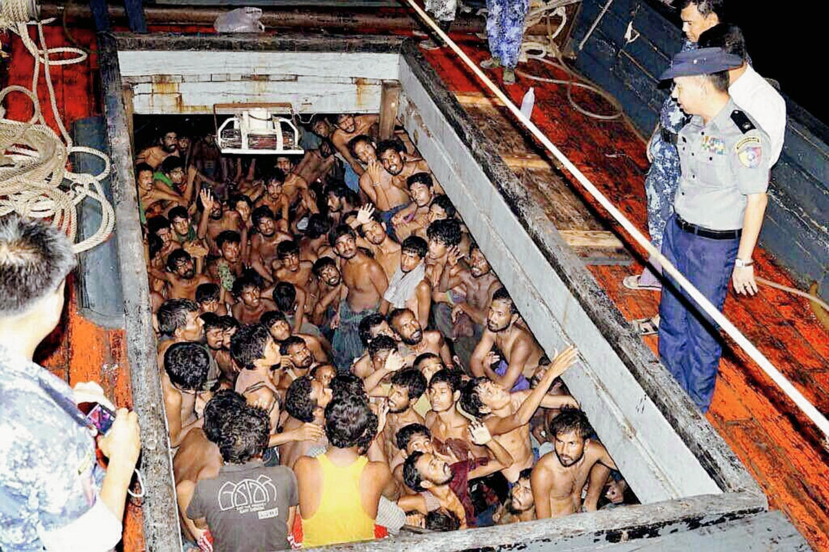 Varios agentes de la Policía birmana que observan a un grupo de inmigrantes en una embarcación en Rakhine, Birmania. (Foto Prensa Libre:EFE9.
