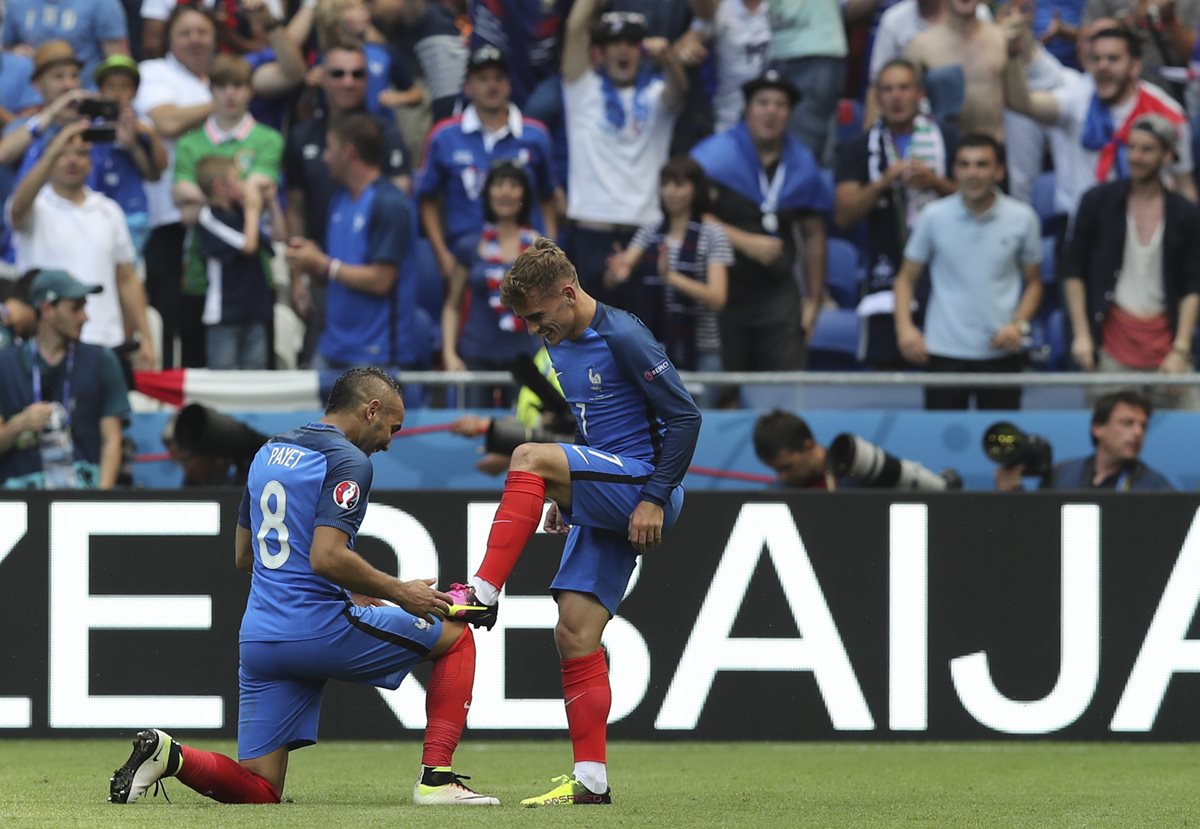 Dimitri Payet limpia los botines de Antoine Griezmann luego del segundo gol. (Foto Prensa Libre: AP)