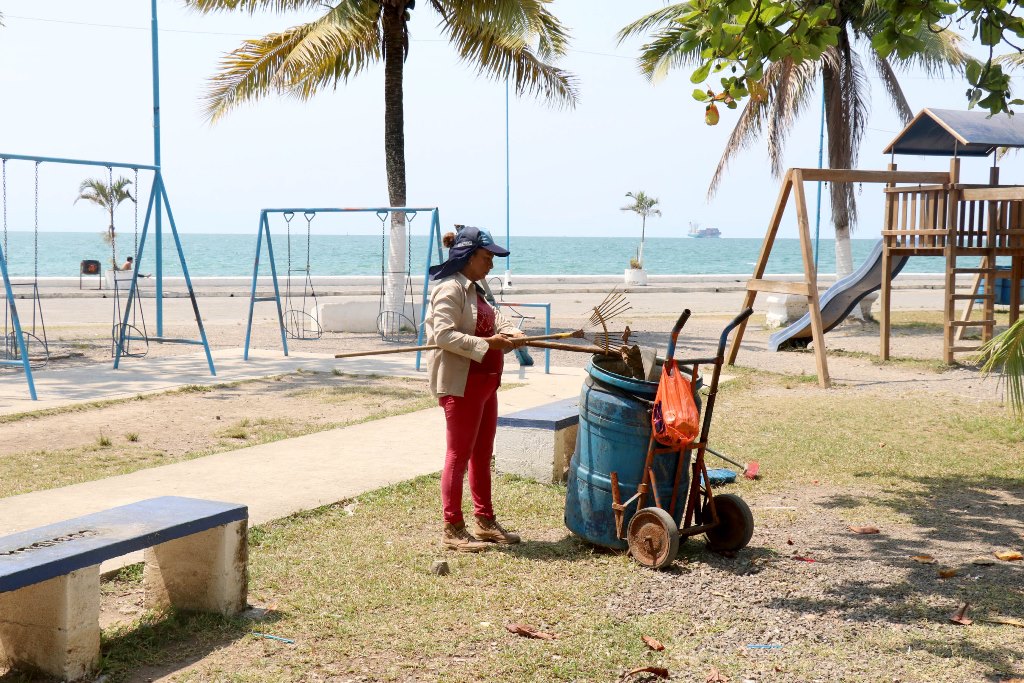 Trabajadora municipal limpia los alrededores del malecón de Puerto Barrios. (Foto Prensa Libre: Dony Stewart)