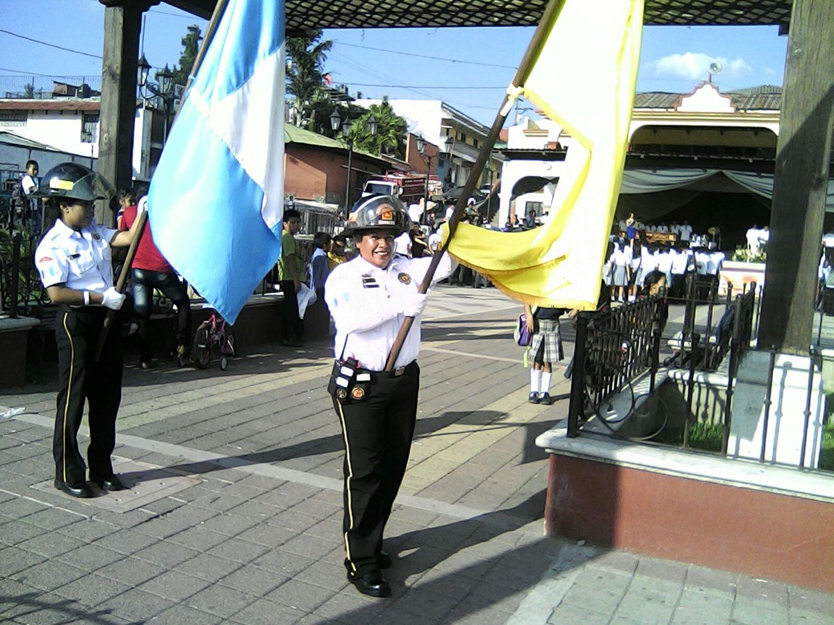 Miriam Luna porta la bandera de los Bomberos Voluntarios. (Foto Prensa Libre: Cortesía)