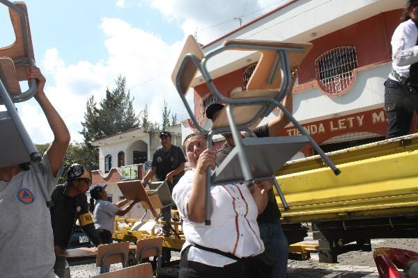 directivos ayudan  a descargar  mobiliario.