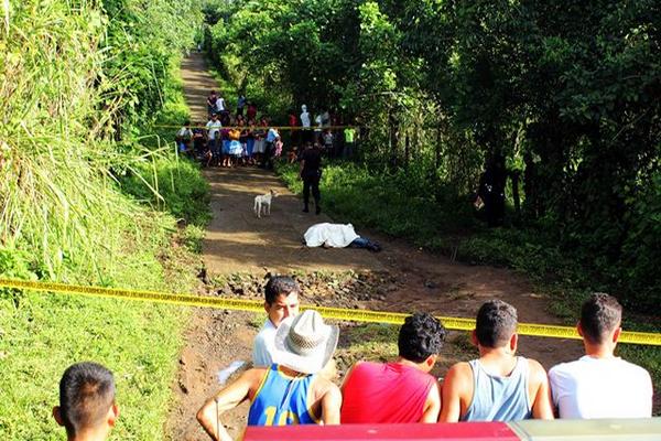 Vecinos de Nuevo San Carlos, Retalhuleu, observan cadáver del guardia particular Álex Geovani González López. (Foto Prensa Libre: Rolando Miranda)
