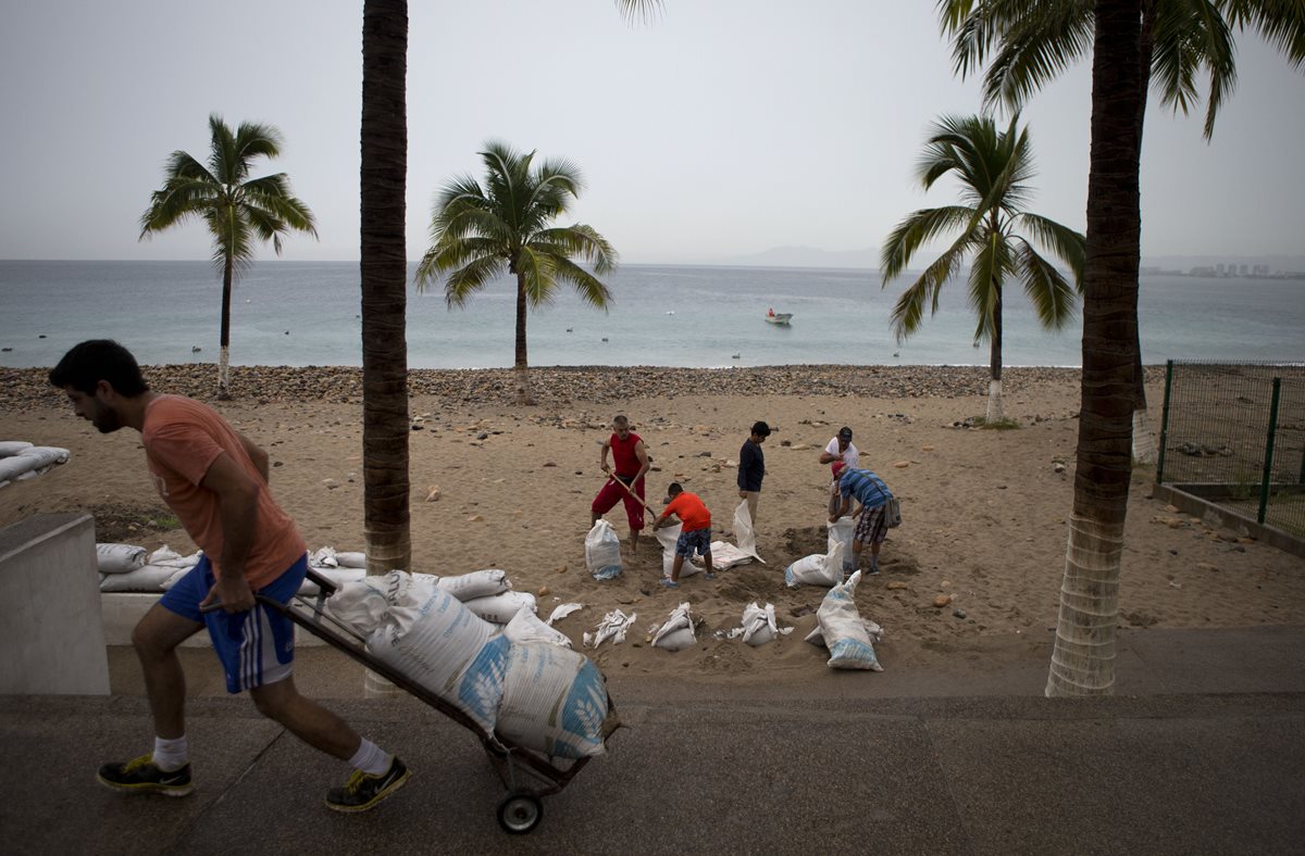 Pobladores evacúan áreas vulnerables. (Foto Prensa Libre: AP).