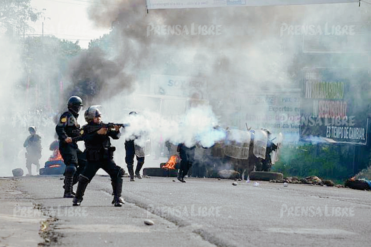 Agentes de  la PNC utilizaron gases lacrimógenos para retirar un bloqueo en el kilómetro 163 de la ruta al suroccidente. (Foto Prensa Libre: Jorge Tizol)
