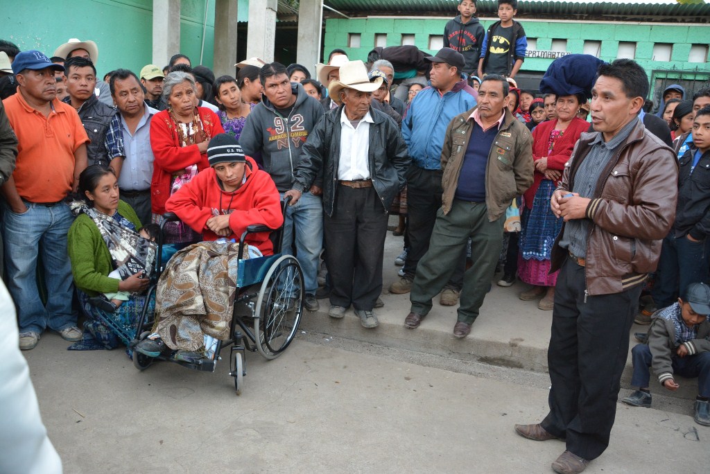 Gregorio Can Ortiz, -en silla de ruedas- habría sido estafado por los dos individuos de chumpa café a la derecha. (Foto Prensa Libre: Édgar Sáenz).