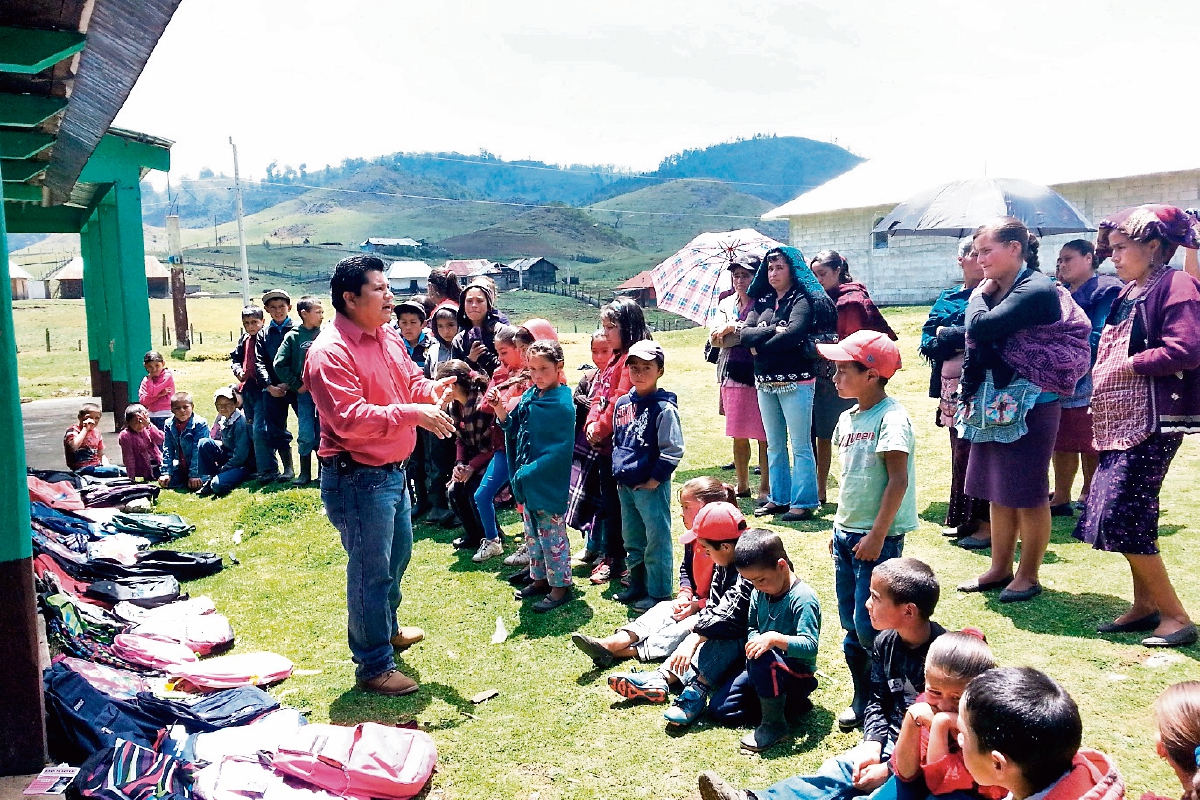 Daniel Mérida —de rojo— entrega donativo a niños de comunidades de Huehuetenango.