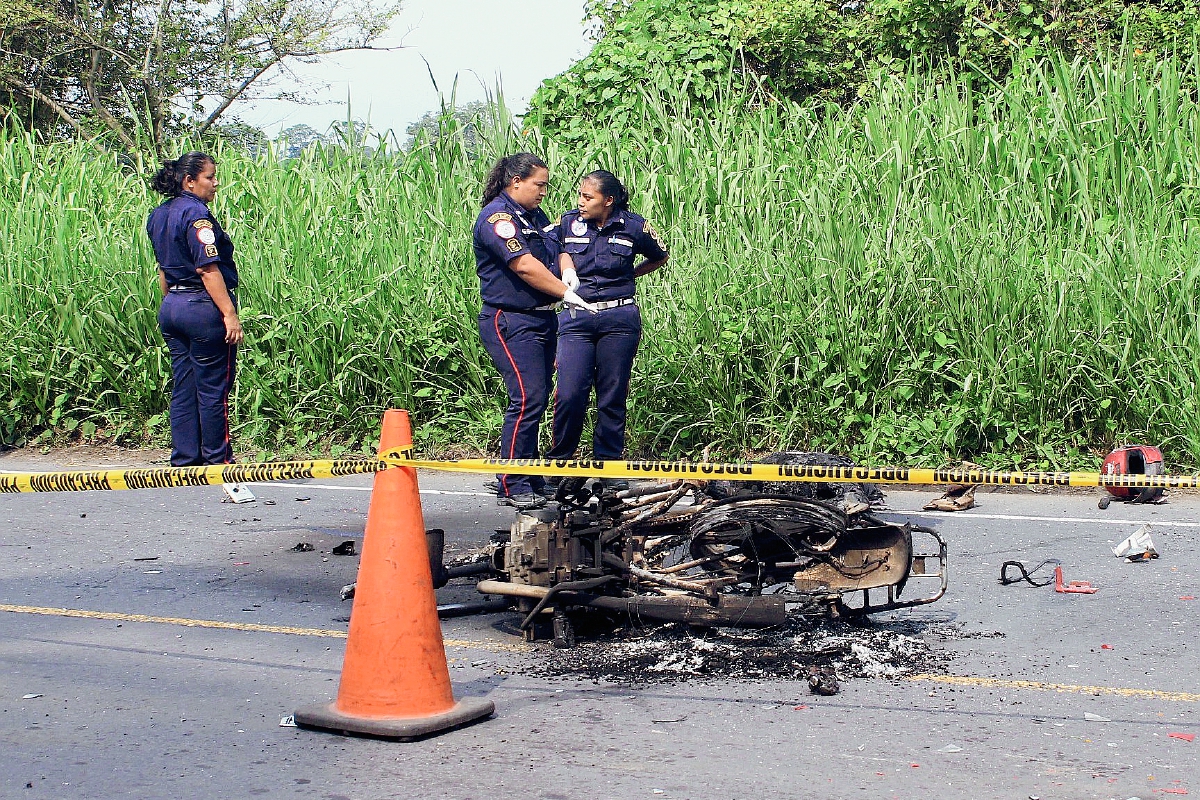 Socorristas observan los restos de la motocicleta en la que se conducía José Antonio Morataya Estrada, quien murió quemado luego de que fue arrollado por camión, en Masagua, Escuintla. (Foto Prensa Libre: Enrique Paredes)