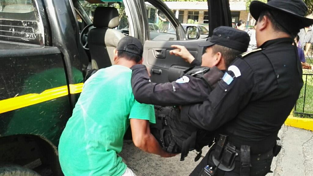 Un vecino y un agente policial trasladan al herido al seguro social de Escuintla. (Foto Prensa Libre: Carlos Paredes)