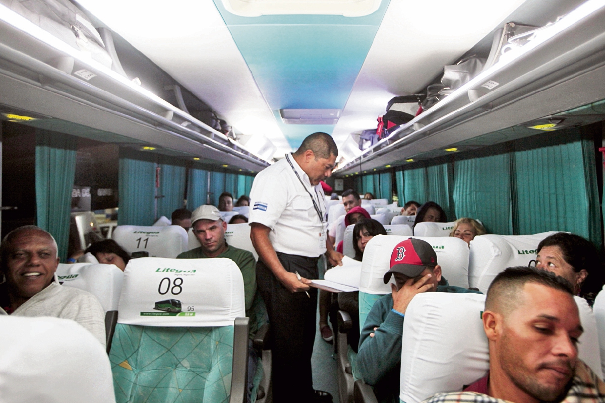 Personal de Migración aborda los cuatro buses para verificar la identidad de los cubanos con sus pasaportes, para permitirles el ingreso en el país.