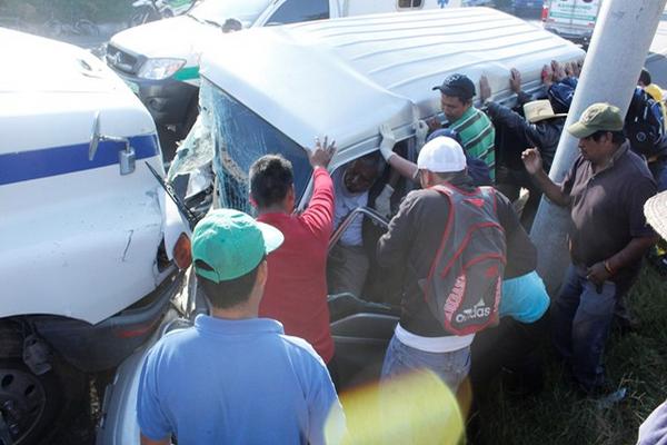 Bomberos municipales de El Tejar, Chimaltenango, cortan parte del microbús para poder rescatar al piloto. (Foto Prensa Libre: Víctor Chamalé).
