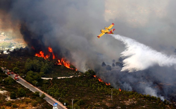 Un avión clanza agua sobre un incendio forestal en Jávea, Valencia. (Foto Prensa Libre: AFP)