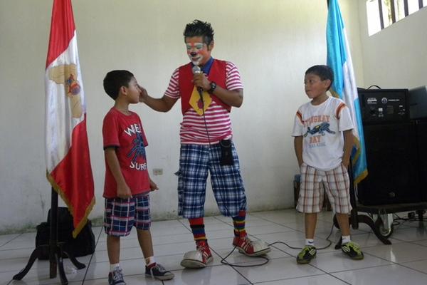 Un payaso comparte con dos niños en actividades para conmemorar el Día de las Personas Sordas. (Omar Méndez)