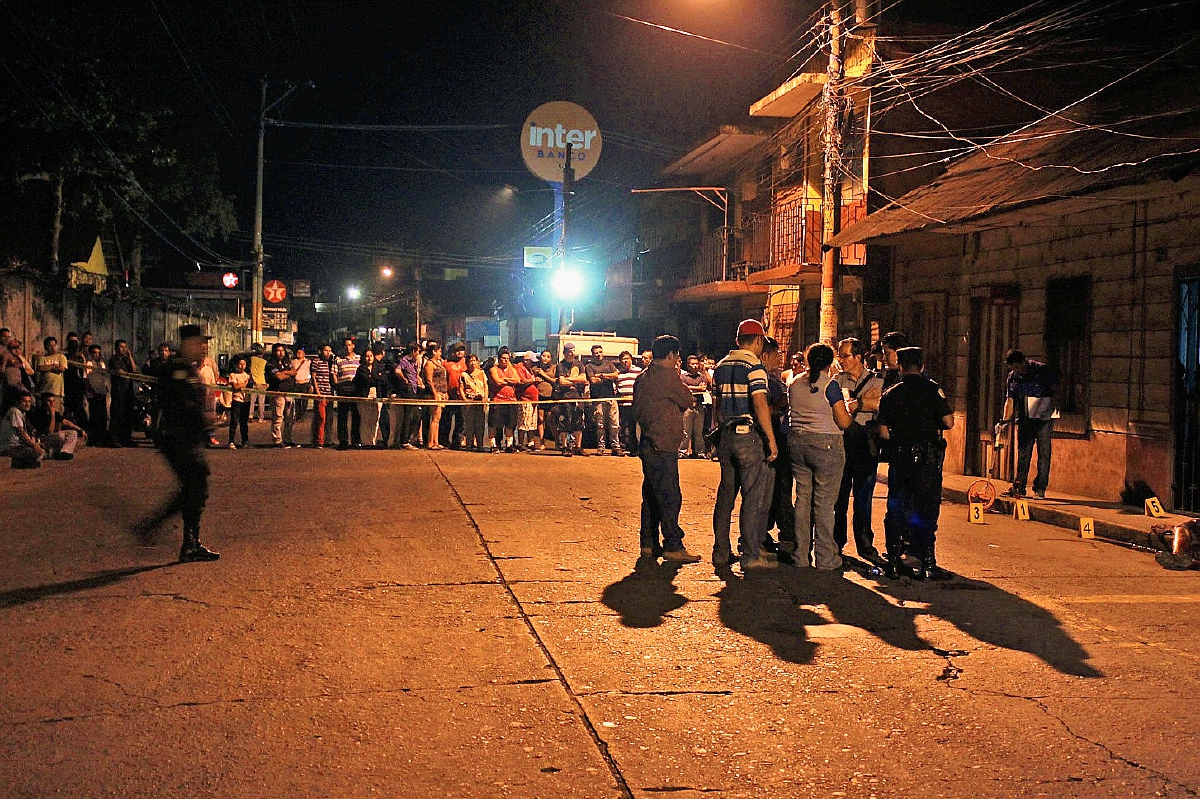 Fiscales del  Ministerio Público acordonan el área en donde un hombre fue muerto a balazos en la zona 1 de Coatepeque, Quetzaltenango. (Foto Prensa Libre: Alexánder Coyoy)