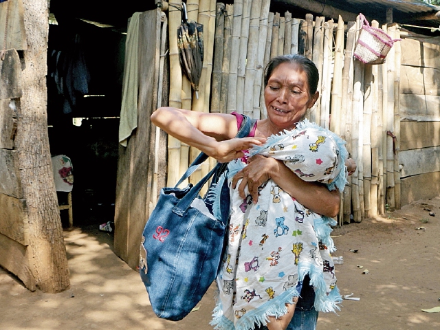 Rut López camina frente a su vivienda, con su hijo Edwin Leonel, de 2 años, en brazos. (Foto Prensa Libre: Rolando Miranda).