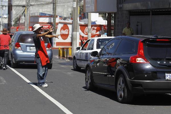 Los <em>jaladores </em>o <em>piratas </em>ofrecen <em>shucos </em>en la calle (Foto Prensa Libre: Álvaro Interiano).<br _mce_bogus="1"/>