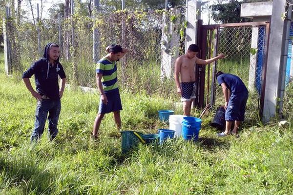 Estudiantes acarrean agua, antes de la suspensión de clases. (Foto Prensa Libre: Hugo Oliva)