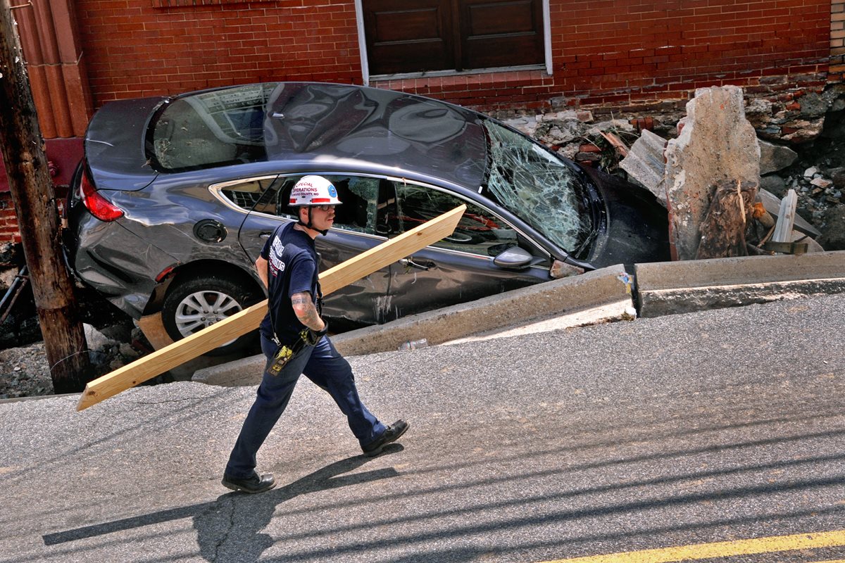 Un socorrista camina frente a un vehículo colapsado en una de las calles de Maryland. (Foto Prensa Libre: AP).