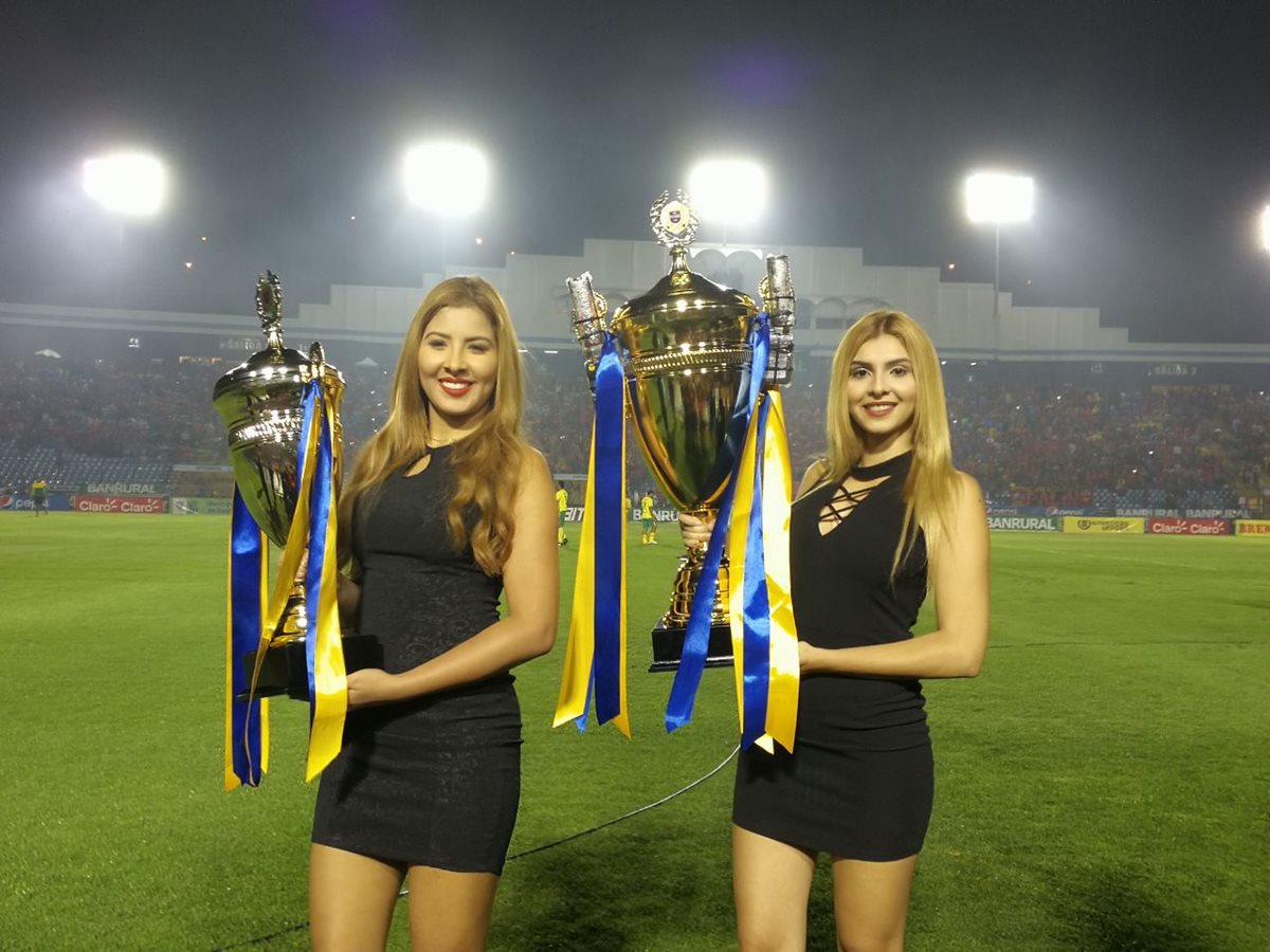 Modelos muestra la Copa de campeón y subcampeón del Clausura.