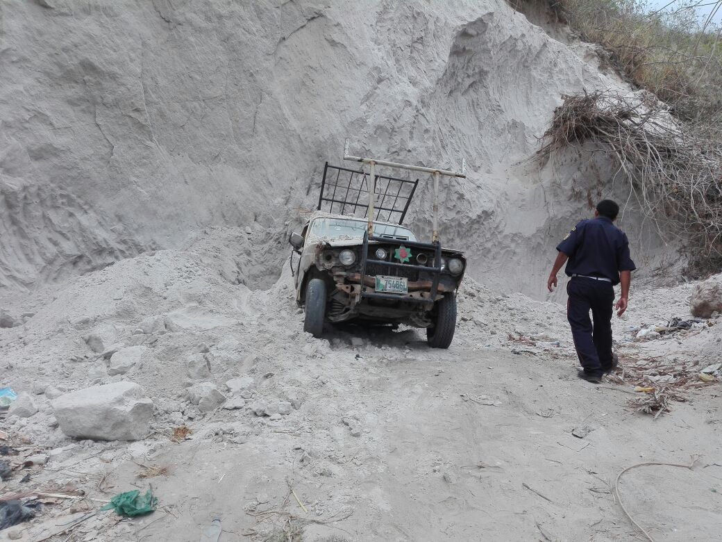 Un socorrista observa el vehículo quedó cubierto por grandes cantidades de tierra. (Foto Prensa Libre: Hugo Oliva)
