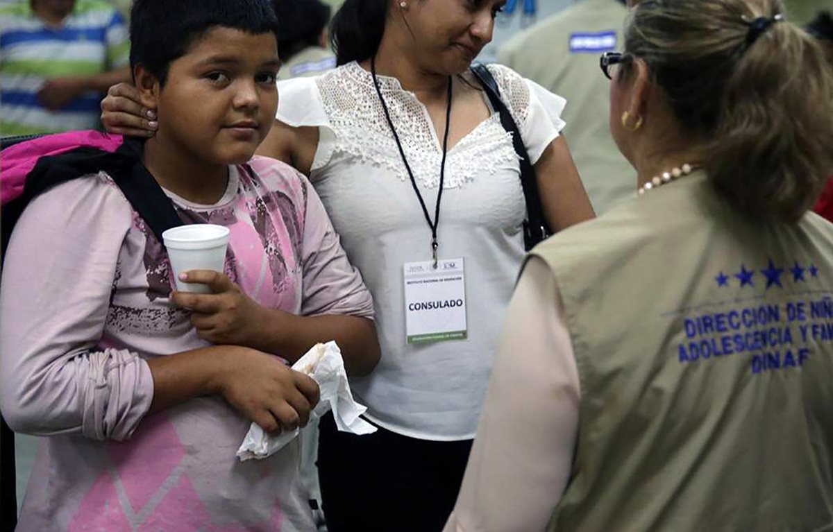 Personal del Consulado hondureño reciben a Mario Castellanos en el aeropuerto de San Pedro Sula. (Foto Prensa Libre: AFP)