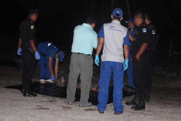Autoridades examinan el lugar donde fue ultimado un hombre de unos 20 años, en San Benito, Petén. (Foto Prensa Libre: Rigoberto Escobar)<br _mce_bogus="1"/>