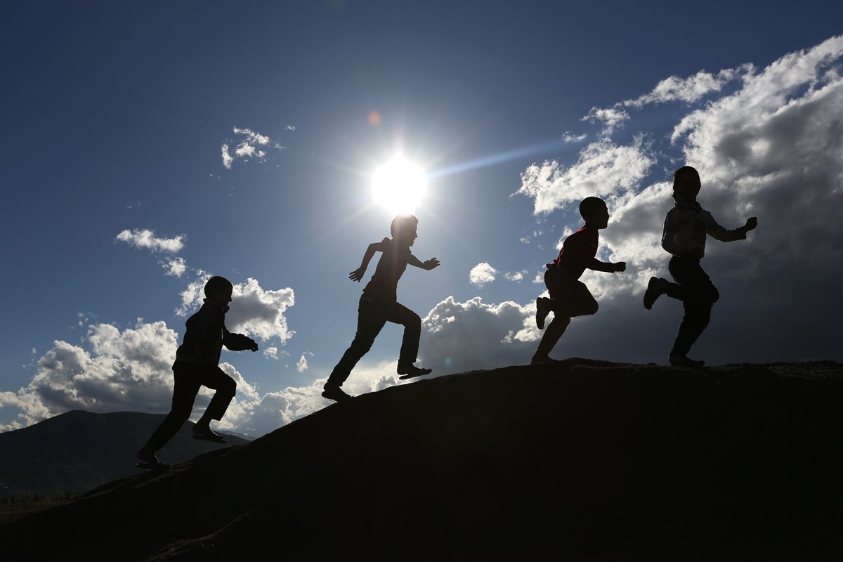 Un grupo de niños afganos juegan al atardecer en Nadir Khan colina en Kabul, Afganistán. (Foto Prensa Libre: AP).