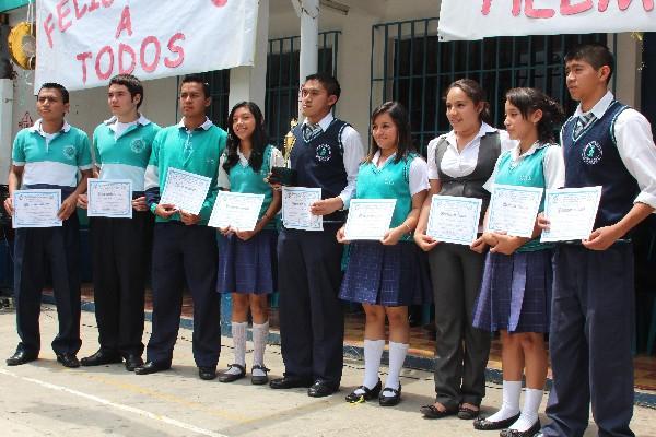Helmer Oswaldo Javier Cruz —al centro— recibe el reconocimiento junto a sus  compañeros.