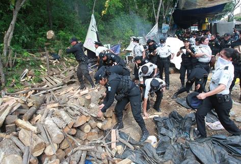 Luego del desalojo, policías retiran leña que utilizan los manifestantes. (Foto Prensa Libre: Estuardo Paredes)