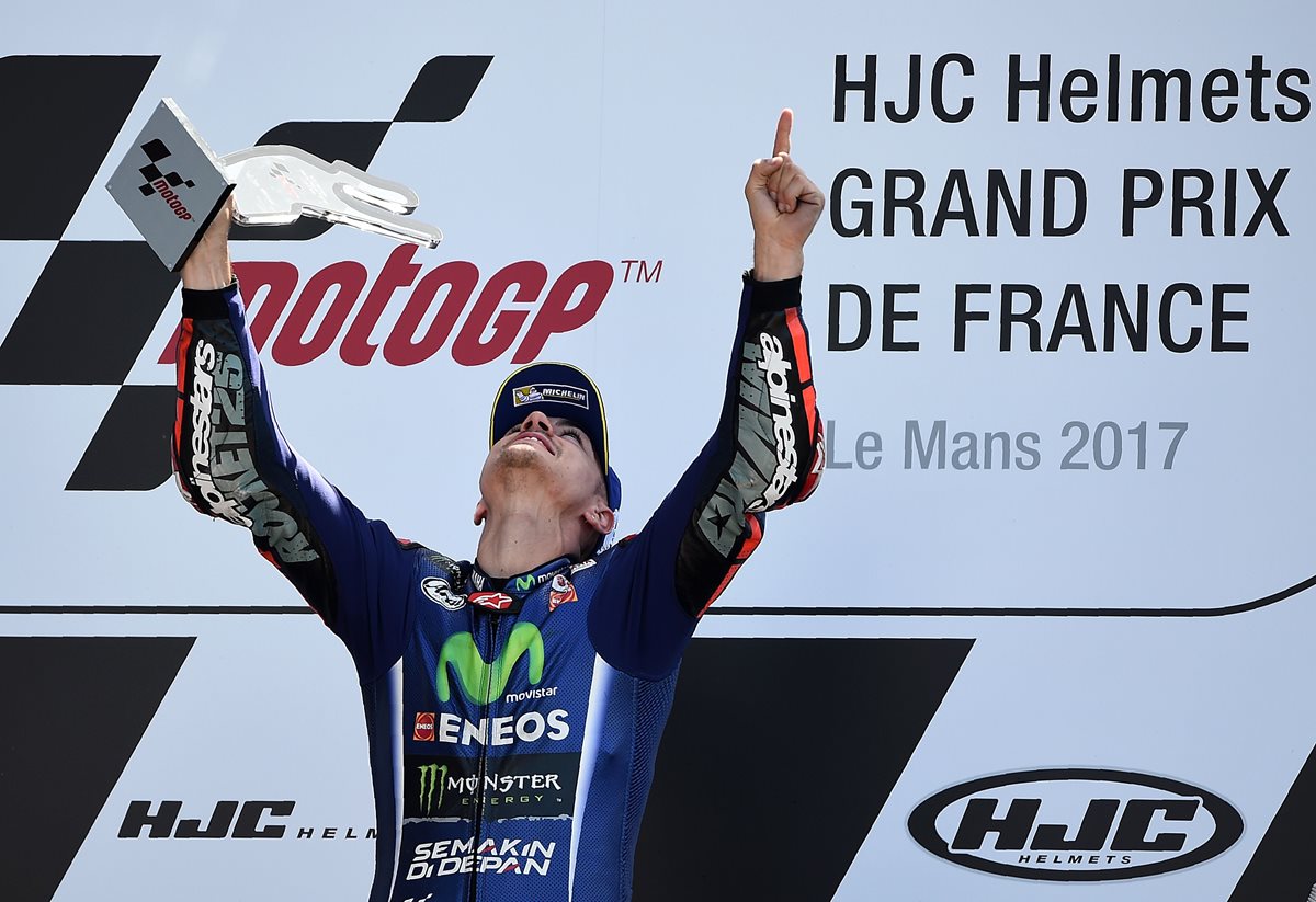 Maverick Viñales festeja en el podio luego de coronarse campeón en Le Mans. (Foto Prensa Libre: AFP)