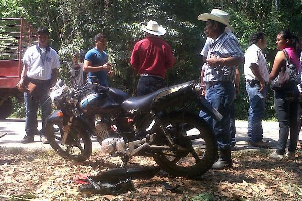 Vecinos permanecen junto a la motocicleta en la que viajaban padre e hijo que se accidentaron, en Sayaxché. (Foto Prensa Libre: Rigoberto Escobar) <br _mce_bogus="1"/>