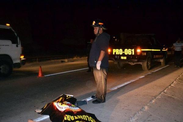 Un socorrista permanece junto al cadáver de Aída Carina López, quien murió atropellada en Sanarate. (Foto Prensa Libre: Hugo Oliva) 