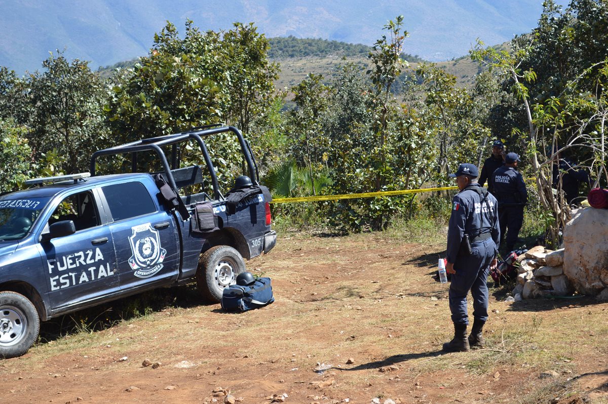 Policías de la Fuerza Estatal resguardan el sitio donde peritos forenses trabajan sobre el hallazgo de las fosas clandestinas, en Zitlala, Guerrero. (Foto Prensa Libre: EFE).