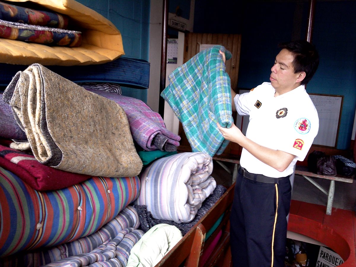 Un socorrista ordena colchas que son utilizadas en el albergue habilitado en la cabecera de San Marcos. (Foto Prensa Libre: Genner Guzmán)
