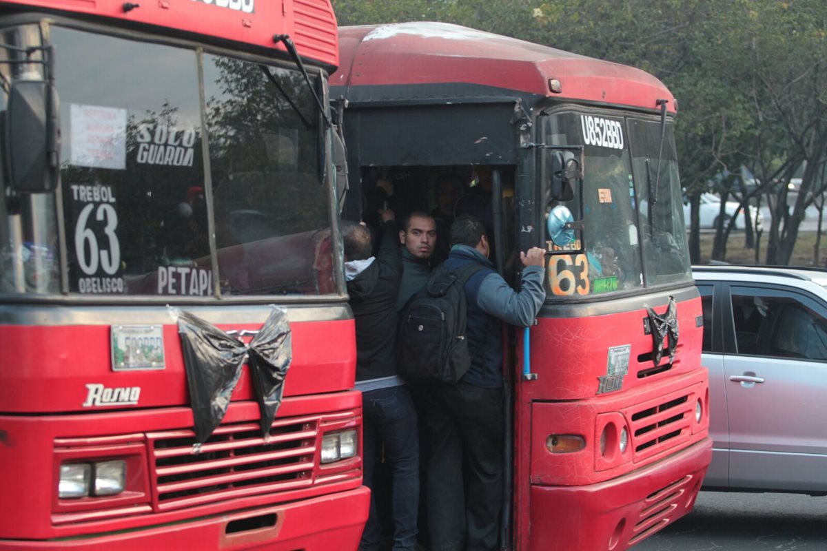 Usuarios del transporte público observan la unidad que quedó estacionada fuera de la estación de bomberos. (Foto Prensa Libre: Erick Ávila)