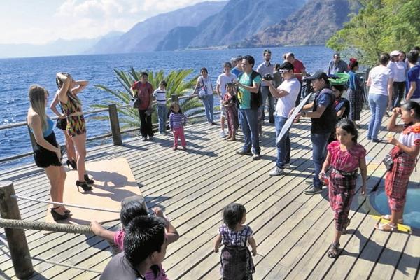 La artista  y el equipo de filmación, en una de las tomas en el mirador del Lago de Atitlán. (Foto Prensa Libre: Ángel Julajuj)