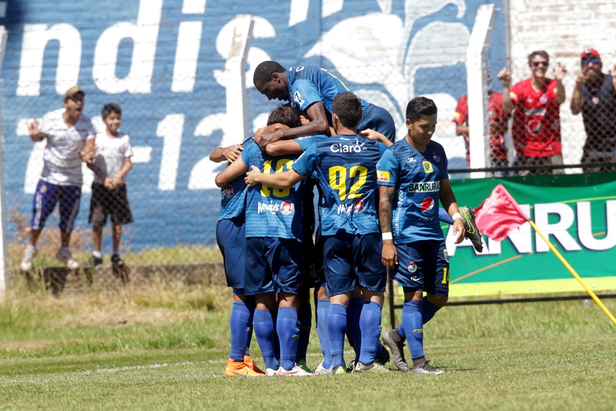 Cristian Jiménez es felicitado por sus compañeros de equipo, luego de anotar dos goles en el duelo frente a Mictlán. (Foto Prensa Libre: Norvin Mendoza)