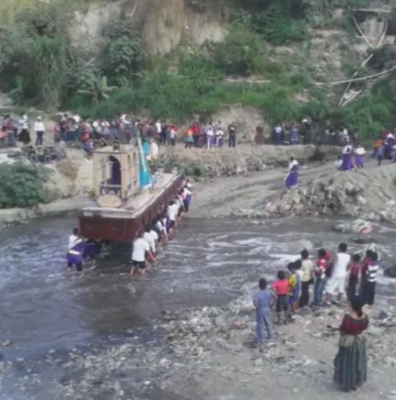 Devotos cargadores caminan descalzos para pasar el río con la imagen de Jesús Nazareno. (Foto Prensa Libre: Youtube)