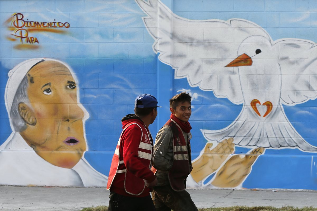 Dos jóvenes pasan frente a un grafiti dedicado al papa Francisco en Ecatepec, Ciudad de México. (Foto Prensa Libre: EFE).
