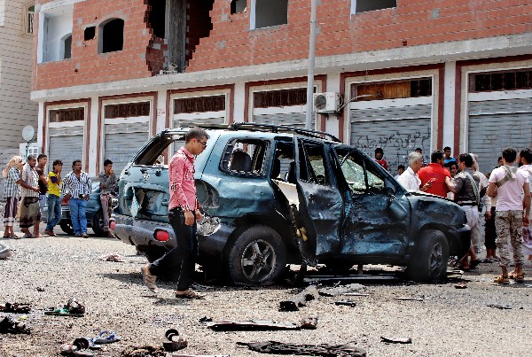 Curiosos observan los daños causados por la serie de atentados en Adén, Yemen. (AP).